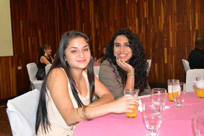 Two beautiful Latin women share a table.